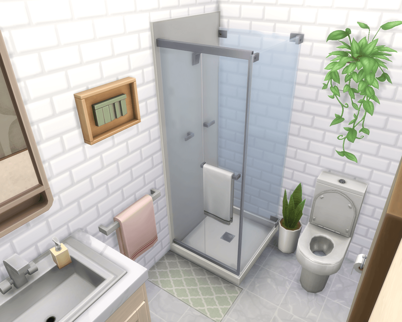 A clean modern bathroom with pink towels, bathrobe, green accents, plant by the toilet and wall plant above the toilet!