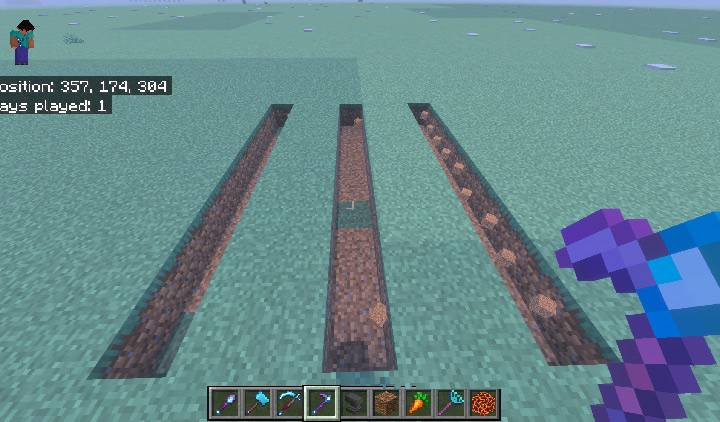 Three parallel dug trenches in a grass field, ready to be flooded