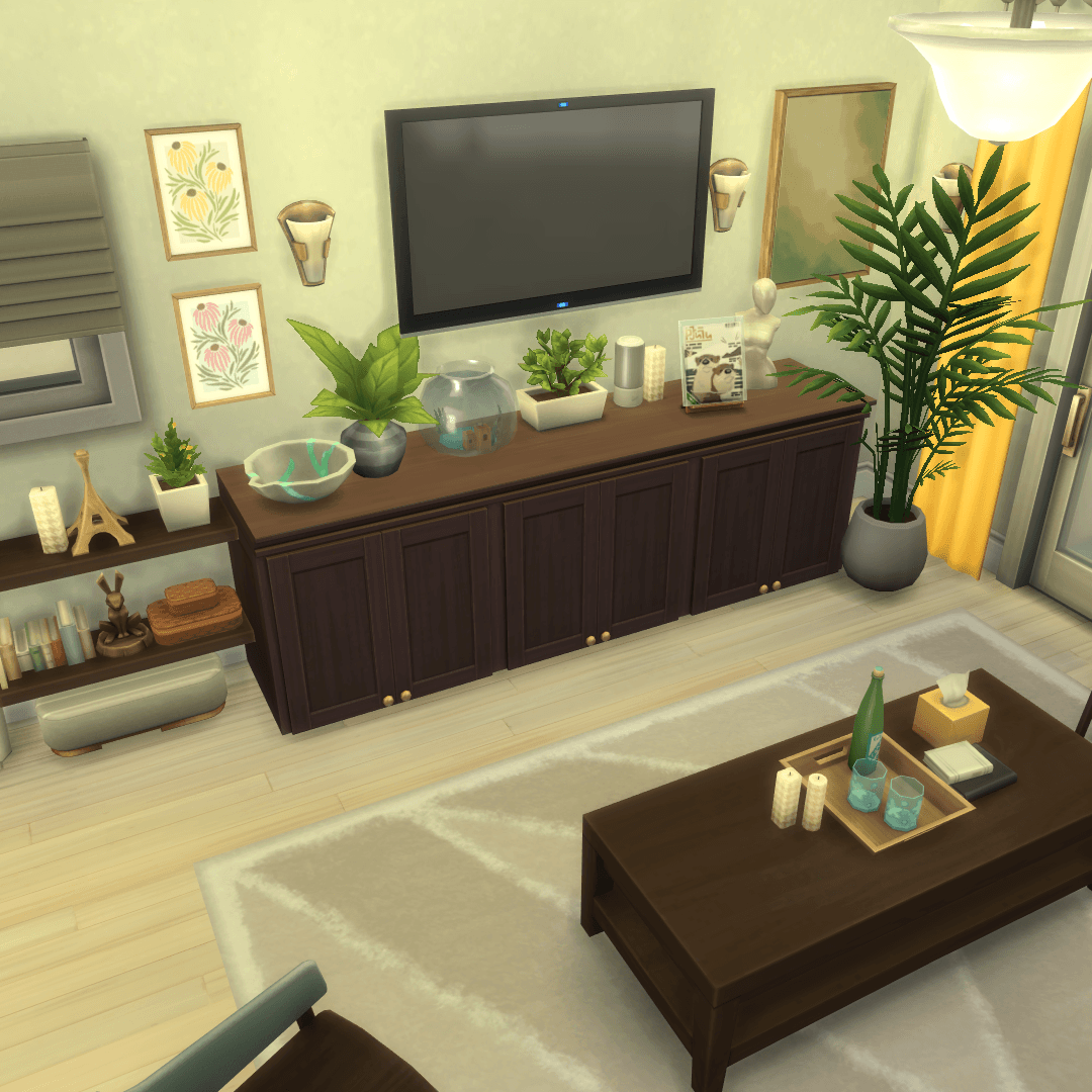 Thumbnail overview of the living room, tv area with shelving, storage cabinets, a fishbowl, speakers, and plants!