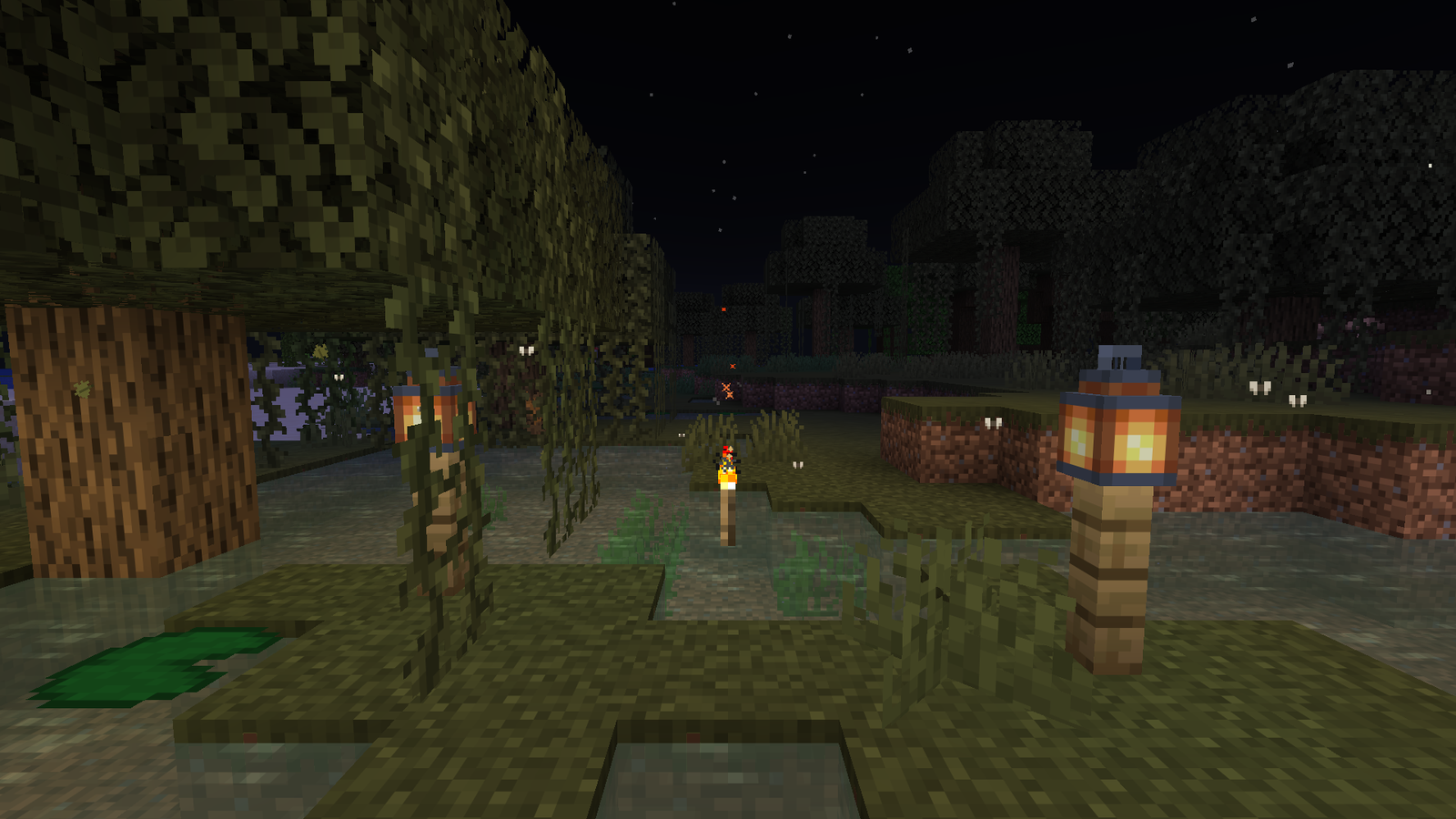 A swamp at night: moths around the torch and lanterns.