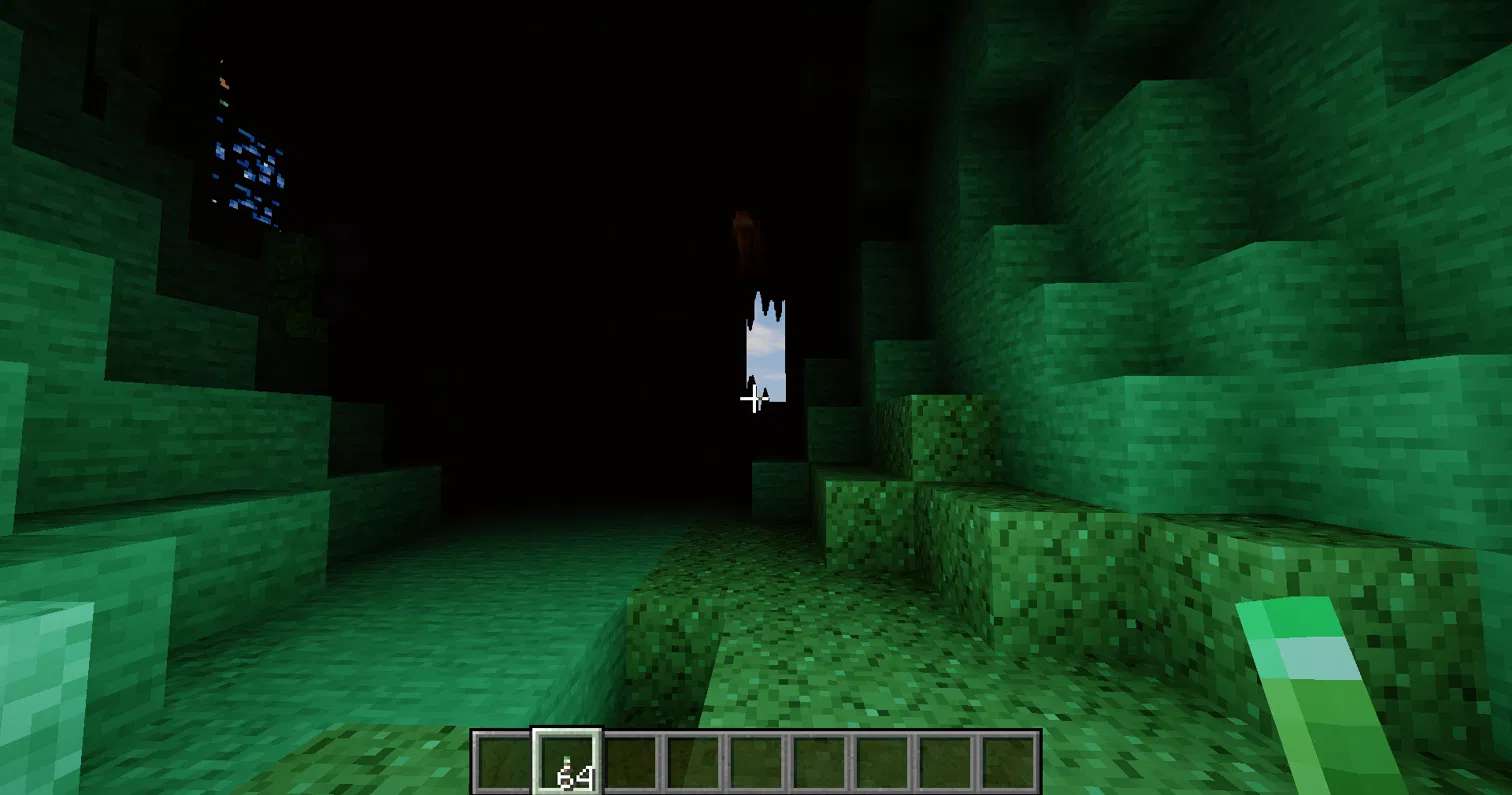 Thumbnail A copper torch in your hand lights the cave in green.