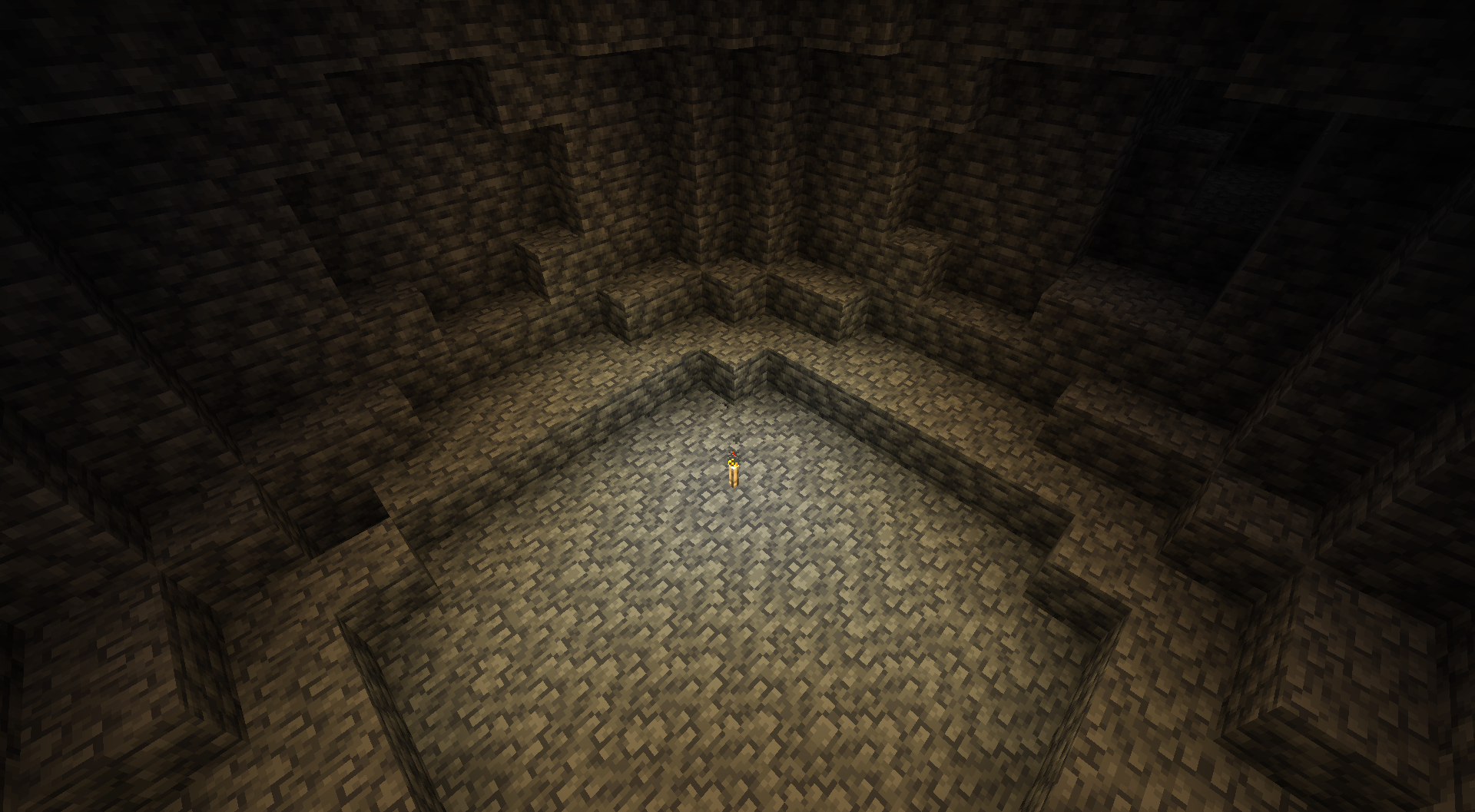 A small cave lit by a torch on the Bright setting.